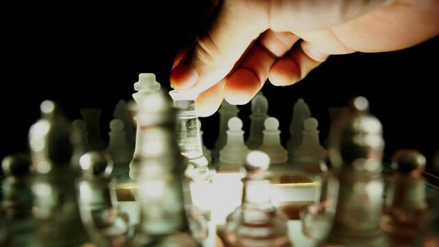 The concept of business competition: Close-up of a businessman holding a glass chess 4K