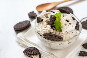 Chocolate cookie and ice cream in a glass bowl with mint leaf on white wooden background, summer sweet and dessert
