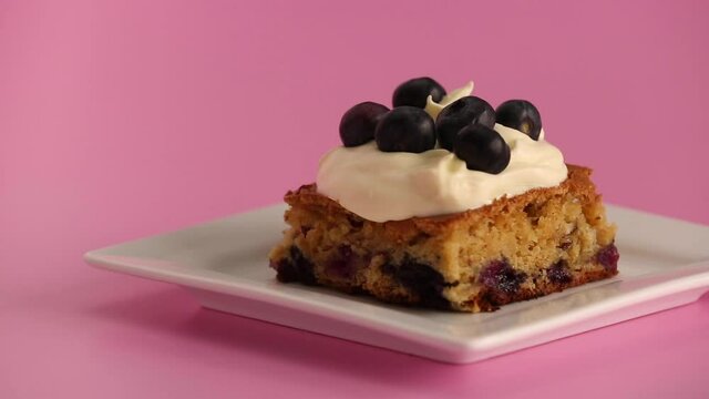 Serving a blueberry blondie brownie with whipped cream on top