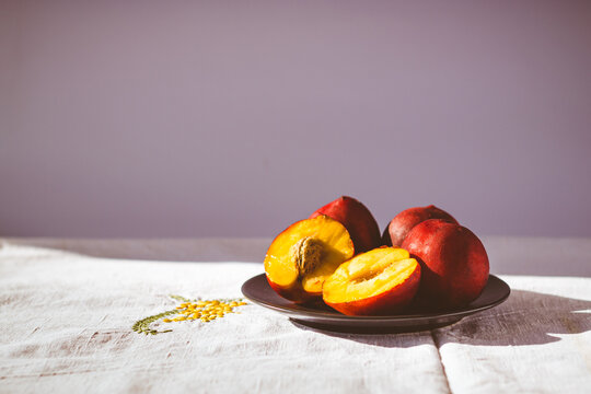 Sitll life con deliciosos duraznos rojos en mesa r&uacute;stica