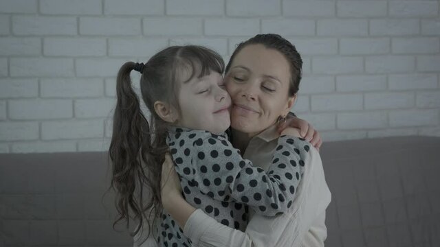 Happy mum hugs indoor. Cute little girl hugs mom.