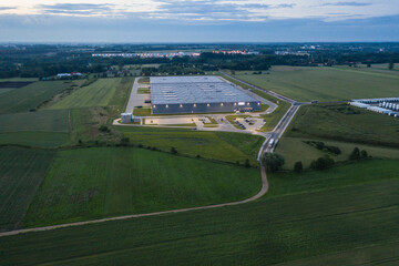 Aerial top down view of the large logistics park with warehouse at Night, loading hub with semi trucks with cargo trailers standing at the ramps for load/unload goods