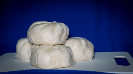 4 steamed buns on the blue background board