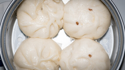 4 steamed buns in a steamer for eating, playing and delicious