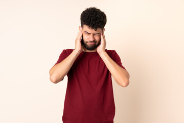 Fototapeta na wymiar Young Moroccan man isolated on beige background frustrated and covering ears