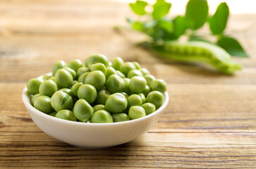 Young green peas in a white bowl.
