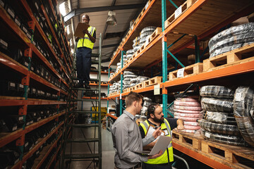 Three male factory workers checking stock at the factory