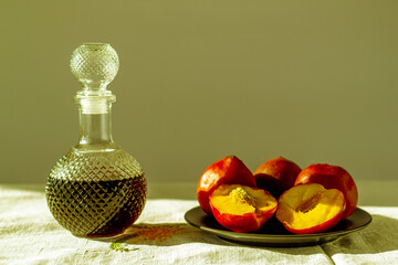 duraznos rojos frescos con una botella de vidrio con licor de cerezas