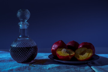 duraznos rojos frescos con una botella de vidrio con licor de cerezas