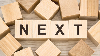 word next with black letters on toy wooden cubes on table