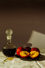 duraznos rojos frescos con una botella de vidrio con licor de cerezas