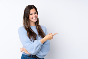 Teenager girl over isolated white background pointing finger to the side