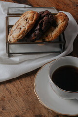 table set with cookies, milk jug and cup of coffee and book on the table