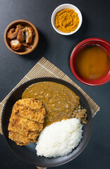 Tonkatsu Curry Rice (Japanese deep-fried pork cutlet with Curry rice) served with karaage (Japanese style fried chicken). top view on black background. flat lay.