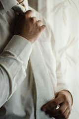 man in white shirt, man in white tie, groom tightens his tie, business style