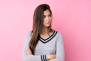 Fototapeta premium Teenager girl over isolated pink background looking side