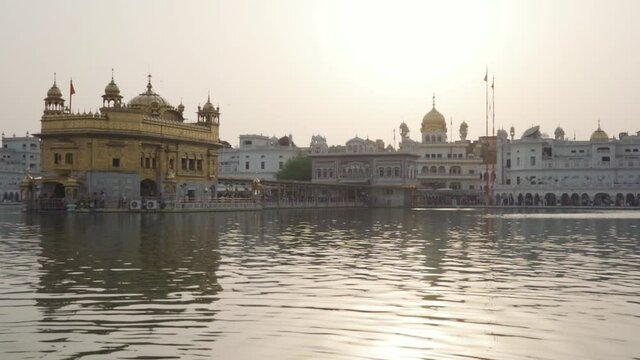 Scenic View Of The Golden Temple In Amritsar, Punjab, India Surrounded By Man-made Sacred Pool - wide shot