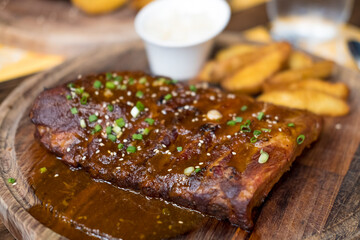 Pork ribs grilled with BBQ sauce on a wooden board