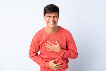 Handsome man over isolated blue background smiling a lot