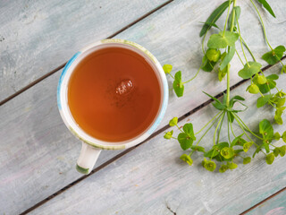 Green tea with a sweet ceramic mug and green fetochka on a wooden blue table
