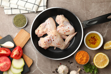 Composition with raw chicken and spices on gray background. Cooking chicken