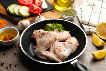 Composition with raw chicken and spices on gray background. Cooking chicken