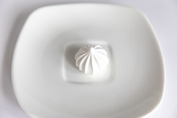 Holiday home baking. White meringues on saucer on isolated white background