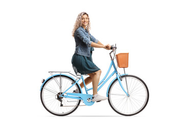 Side shot of a young female riding a bicycle and looking at the camera