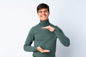 Handsome man over isolated blue background holding copyspace imaginary on the palm to insert an ad
