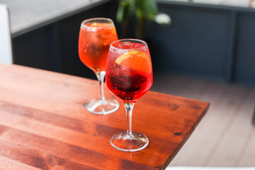 Two glasses of traditional Italian cocktails - Aperol and Campari spritz on a table in a cafe