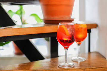 Two glasses of traditional Italian cocktails - Aperol and Campari spritz on a table in a cafe