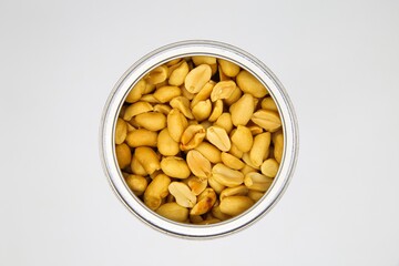 Top view close up of isolated open can with roasted salted peanuts, white background