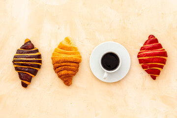 Set of coffee with croissants - chocolate, berry, classic - on stone table