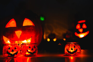 Many Halloween Pumpkin glowing faces in a row on dark black background. greeting card