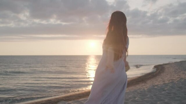 Happy woman dancing on beach during sundown