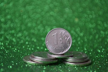 Russian metal 1 ruble on a stack of coins on a green shiny background
