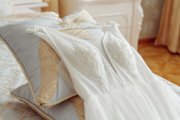 Wedding dress with hanger laying on the bed