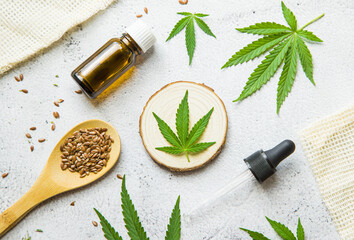 Obraz na płótnie Canvas flat lay composition top view. Marijuana leaves, cannabis oil and Hemp seeds. Glass bottle with CBD oil, THC tincture. Cosmetics CBD oil