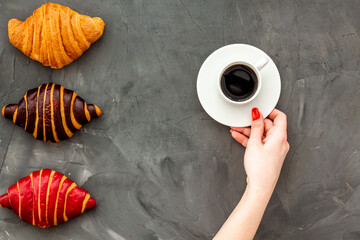 Coffee and croissants on dark stone table top view