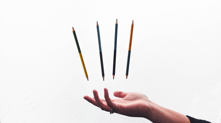 lapices de colores flotando sobre mano en fondo blanco, arte y dibujo, cuatro lapices de doble punta de colores, pinturas 