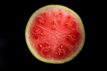 Pieces of watermelon in a black tray on a black background