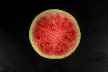 Pieces of watermelon in a black tray on a black background