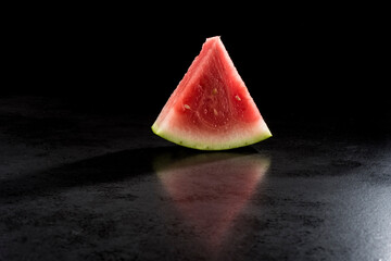 Pieces of watermelon in a black tray on a black background