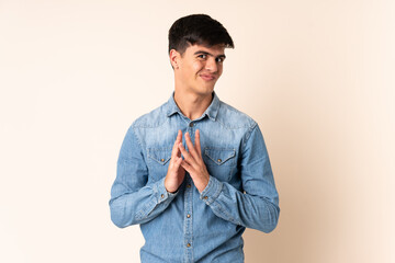 Handsome man over isolated beige background scheming something