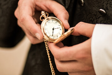 pocket watch in hands holding old clock