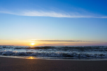 Sunset over the sea. Reflection of sunlight in the sea waves. The sky in the sunset rays. Russia Baltic Sea.