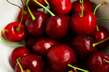 A lot of fresh sweet cherry fruit berries with water drops, close up. Pile of ripe cherries. Large collection of fresh red cherries. Ripe cherries texture background