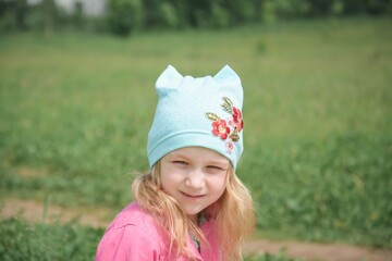 beautiful little girl plays in the summer park