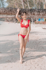 Fototapeta premium Young sexy woman in bikini enjoying summer vacation on beach relaxing holiday