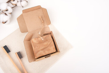 Bath accessories, eco theme, rejection of plastic as a sustainable way of life. Handmade soap and wooden toothbrushes on a white background, top view, copy space.